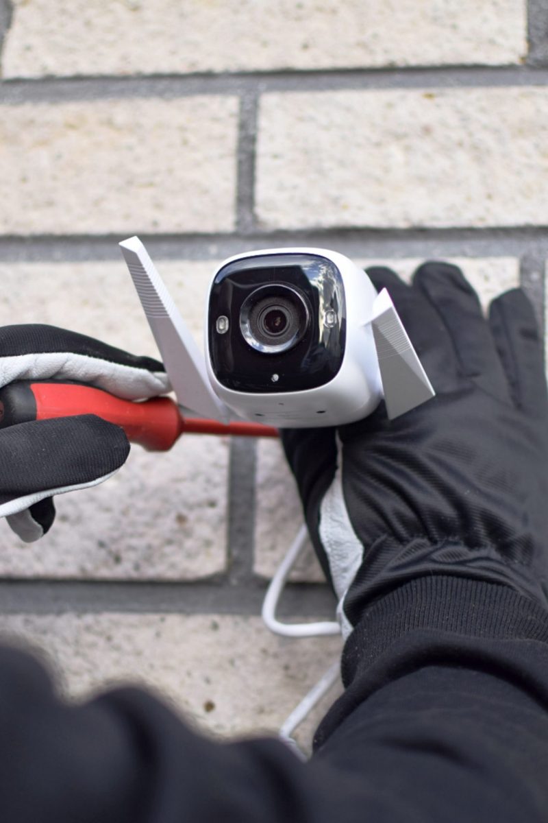 person-installs-surveillance-camera